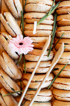 Stuffed Bagel with salmon creme chess and dill. Placed on top of a board in a row.