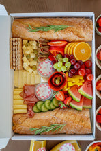 Lade das Bild in den Galerie-Viewer, Charcuterie Box including baguette, cheese, sausages, fruits, veggies, dips and jam. Decorated beautifully in a catering box. 
